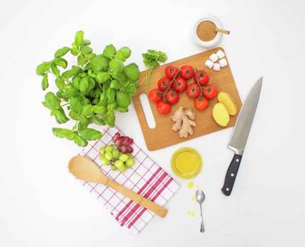 Sastojci za pametne kuhinjske trikove koji pojednostavljuju život poput rajčica i noževa, krumpira, smeđeg šećera, maslinovog ulja, bilja i grožđa.