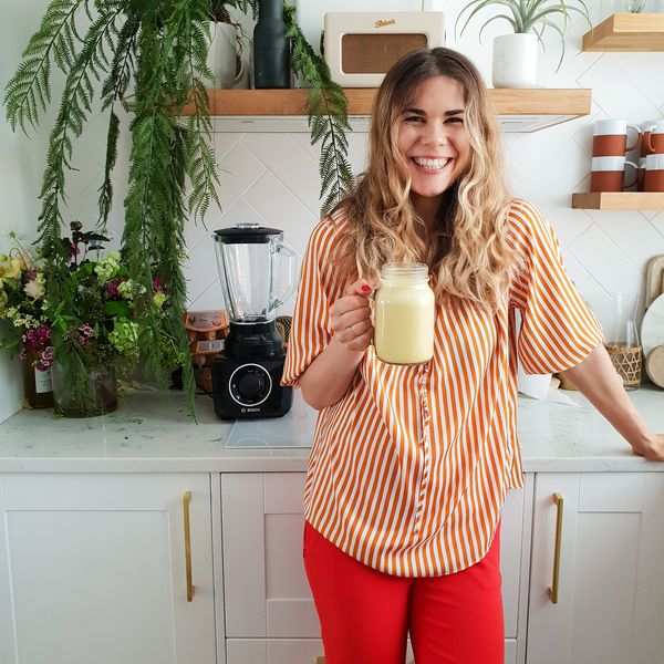 Woman holding large drink in kitchen