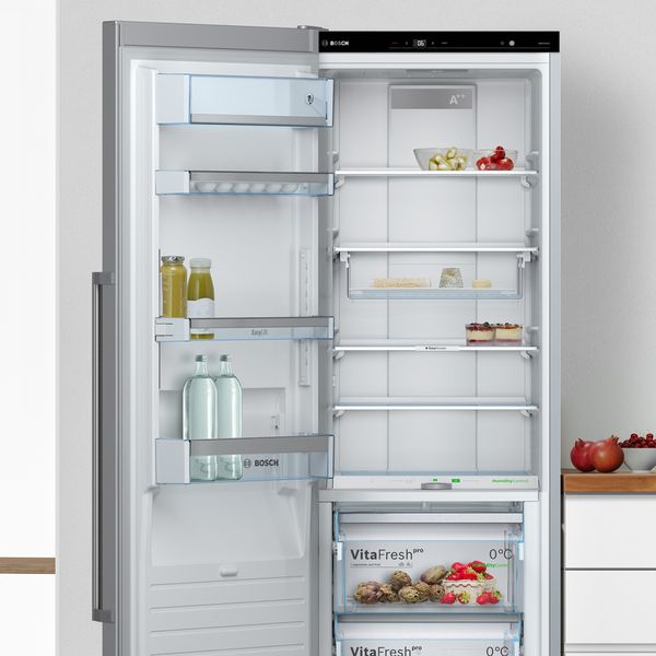 Bosch freestanding fridge freezer open in kitchen showing contents