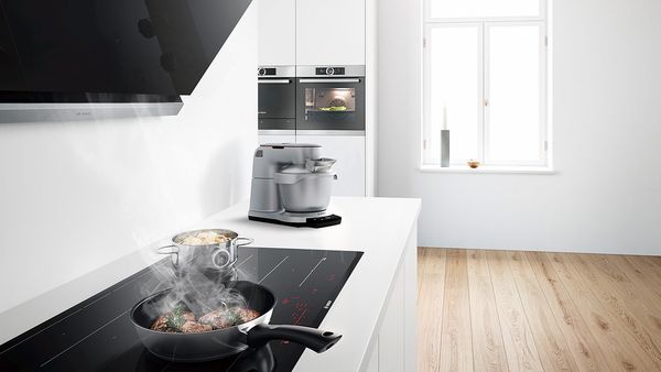Bosch Hob in kitchen cooking food in pot and pan using cookingSensor plus.