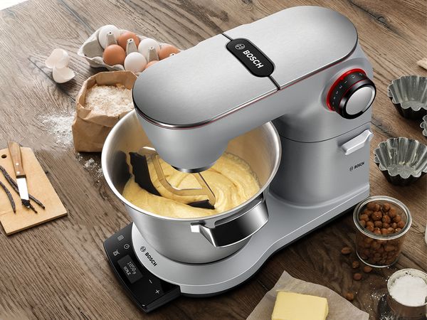 Optimum Machine with dough mixing on table in kitchen