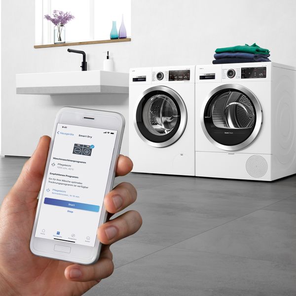 Washer dryer appliances with Home Connect app open on mobile