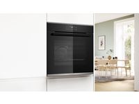 &Aring;pen Bosch ovn med digitalt kontrollpanel, to rister og en moderne, elegant design i et lyst kj&oslash;kkenmilj&oslash;.