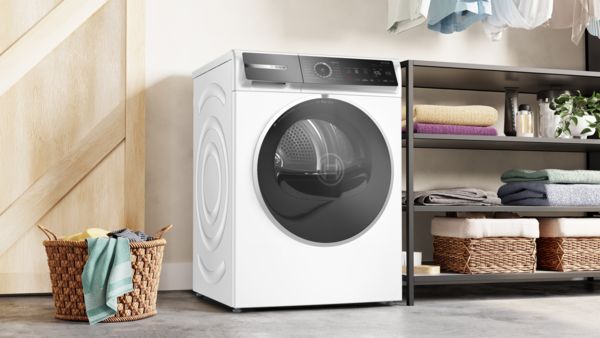 Ένα πλυντήριο-στεγνωτήριο Bosch σε ένα μοντέρνο λευκό μπάνιο